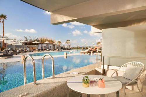 a view of the pool at a resort with tables and chairs at Nautilux Rethymno by Mage Hotels in Rethymno Town