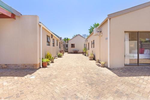 a brick driveway leading to a building with potted plants at 2 On Lismore Guesthouse in Tokai