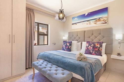 a bedroom with a large bed with a blue comforter at 2 On Lismore Guesthouse in Tokai