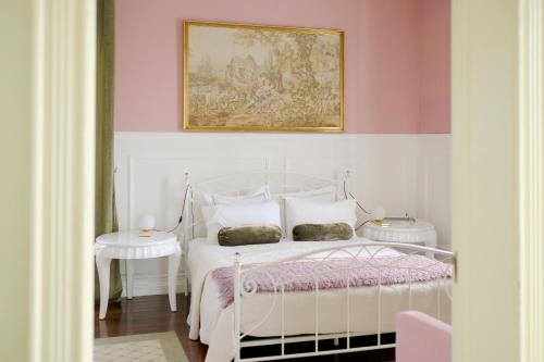 Un dormitorio con una cama blanca y una pintura en la pared en Villa Várzea - Garden Suite en Várzea