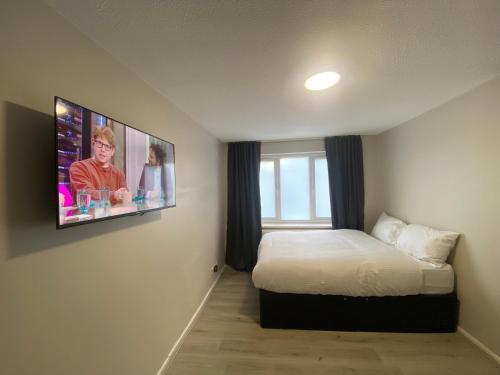 a bedroom with a bed and a tv on the wall at Hosted By Ryan - 1 Bedroom House in Liverpool