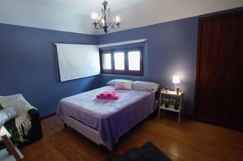 a blue bedroom with a bed with pink towels on it at Precioso Chalet Vista Mar in Mar del Plata