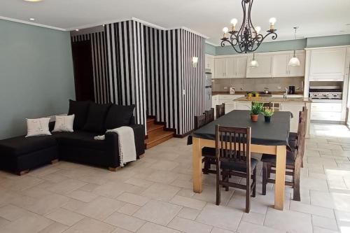 a kitchen and living room with a table and a couch at Precioso Chalet Vista Mar in Mar del Plata
