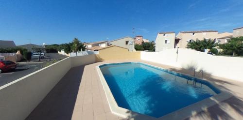 - une piscine sur le côté d'une maison dans l'établissement Maison Résidence Golf Club Cap Agde, au Cap d'Agde