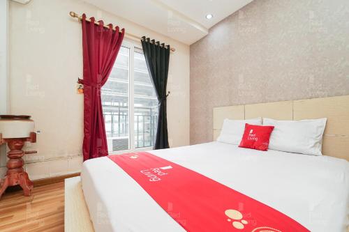 Un dormitorio con una cama con una manta roja. en RedLiving Apartemen Sunter Park View - Emma Rooms, en Yakarta