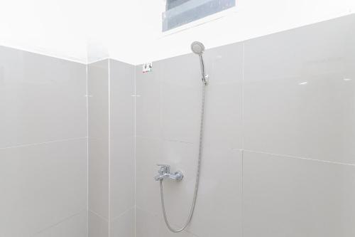 une douche avec pommeau de douche dans une salle de bain dans l'établissement RedDoorz Syariah near GOR Bung Karno Nganjuk, à Nganjuk