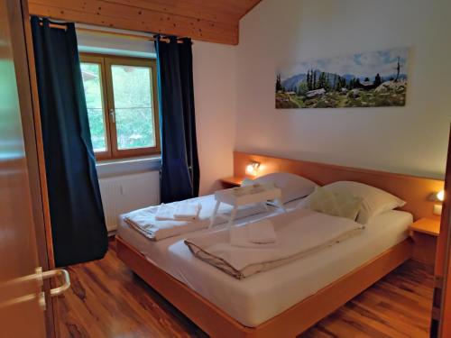 ein Schlafzimmer mit einem Bett und einem Fenster in der Unterkunft ciao-aschau Grenzhub FeWo Alpen Hidaway 110 in Aschau