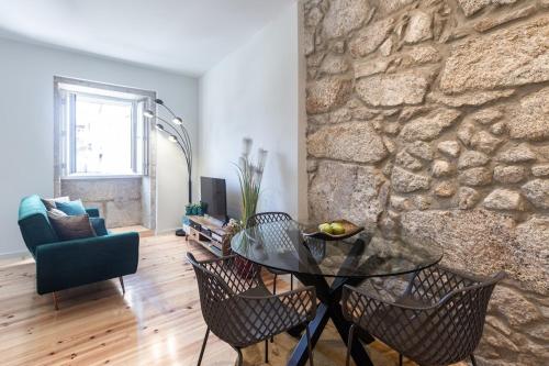 a living room with a stone wall and a glass table at Swimming Pool Luxury House 1 in Porto