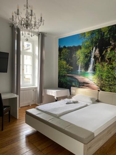 a bedroom with a waterfall painting on the wall at Hotel St. Hubertus in Wallmerod