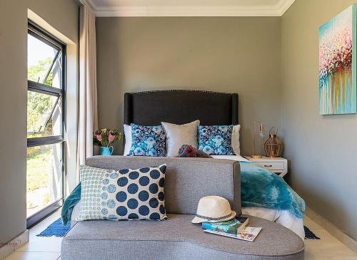 a bedroom with a bed and a couch with a hat on it at 2 On Lismore Guesthouse in Tokai