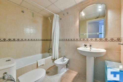 y baño con lavabo, aseo y espejo. en Apartamento Apolo XVI 2 19 - Grupo Turis, en Calpe