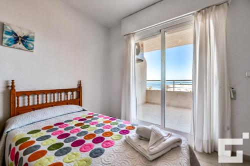 ein Schlafzimmer mit einem Bett mit Blick auf das Meer in der Unterkunft Apartamento Apolo XVI 2 19 - Grupo Turis in Calpe