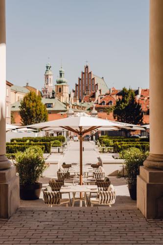 a group of tables and chairs with an umbrella at Hotel Verte, Warsaw, Autograph Collection in Warsaw
