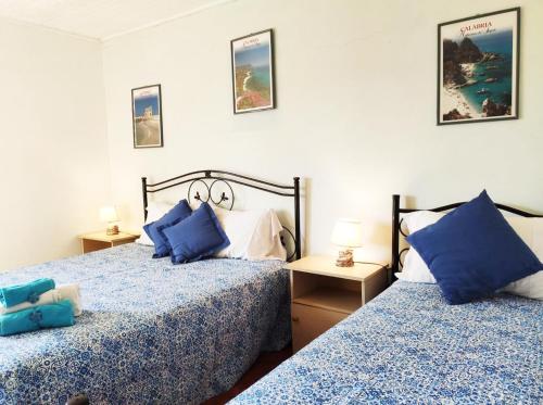 イーゾラ・ディ・カーポ・リッツートにあるIppocampo Holiday Homeのベッドルーム1室(青い枕のベッド2台付)