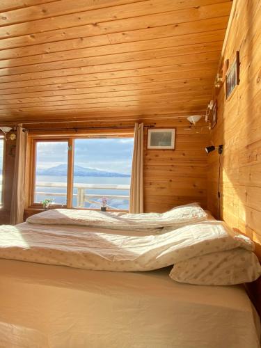 a bedroom with a large bed with a window at Bogen Hostel in Bogen