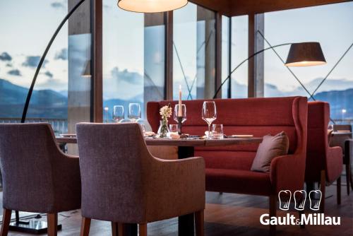 una sala da pranzo con tavolo, sedie e finestre di Hotel Ansitz Rungghof ad Appiano sulla Strada del Vino