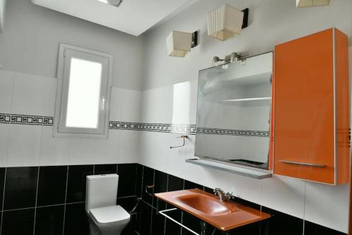 ein Bad mit einem Waschbecken, einem WC und einem Fenster in der Unterkunft Golden Coast Panagias Apartment in Volos