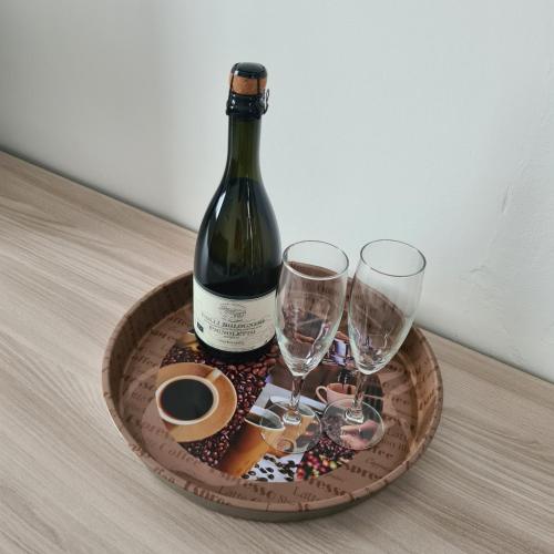a bottle of wine and two glasses on a tray at via Matteotti 102 in Bazzano