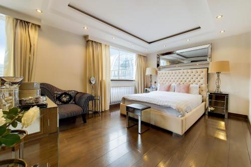 a bedroom with a large bed and a couch at The Portman Residences in London