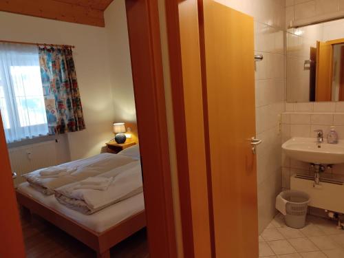 uma pequena casa de banho com uma cama e um lavatório em ciao-aschau Grenzhub FeWo 312 Göke em Aschau