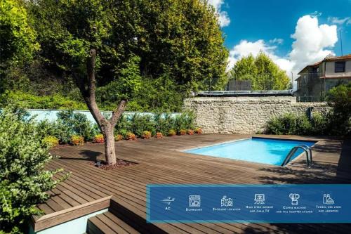 a swimming pool with a tree and a wooden deck at Swimming Pool Luxury House 2 in Porto