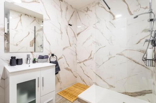 uma casa de banho com uma parede em mármore em 7P céntrico piso con encanto em Valência