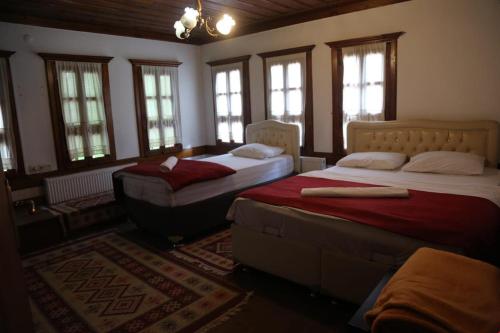 um quarto com 2 camas num quarto com janelas em mehmet efendi em Saframbolu