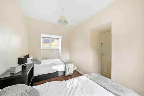 - une chambre avec 2 lits et une fenêtre dans l'établissement 4 bed Townhouse- Free parking, à Londres