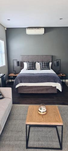 a bedroom with a large bed and a coffee table at Cottage in Sandton in Johannesburg