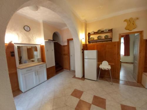 uma cozinha com um arco e um frigorífico branco em Balatonszemesi Nyaralóház em Balatonszemes