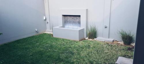 a yard with a fireplace in the side of a house at Cottage in Sandton in Johannesburg