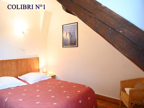 Schlafzimmer mit einem Bett mit einer roten Tagesdecke in der Unterkunft Le colibri in Étretat