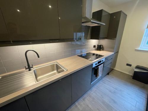 una cucina con lavandino e piano di lavoro di Modern Cosy 1 Bed Apartment near City Centre~Double Bed~Parking a Manchester