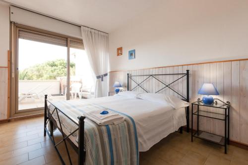 1 dormitorio con cama grande y ventana grande en Etruria Residence, en San Vincenzo