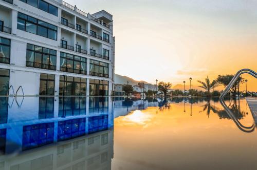 un edificio y una piscina de agua frente a un edificio en Mc Palace Hotel Spa & Convention en Kyrenia