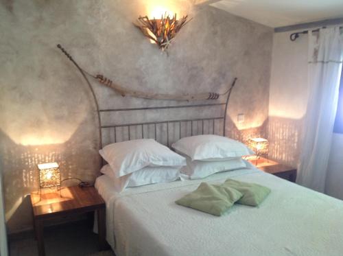une chambre avec un lit blanc avec deux oreillers dans l'établissement Villa St Exupery, à Oletta