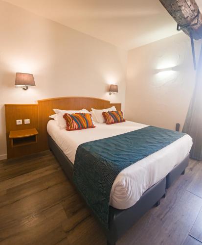 a bedroom with a large bed with two pillows at Hôtel Posta Vecchia in Bastia