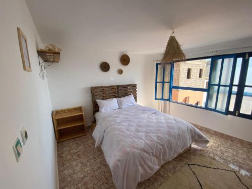 a bedroom with a large bed and a window at Sable beach surf camp taghazout in Taghazout