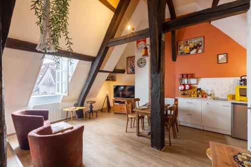 Il comprend une cuisine et une salle à manger avec des murs orange et du parquet. dans l'établissement Le Grand St Aignan - Appt centre ville pour 2, à Chartres