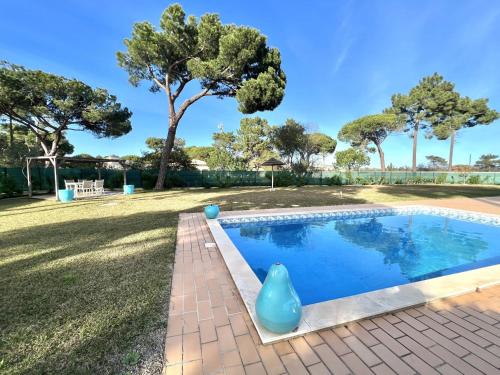 uma piscina num quintal com árvores ao fundo em Vila Caravela - Private Pool by HD Properties em Vilamoura