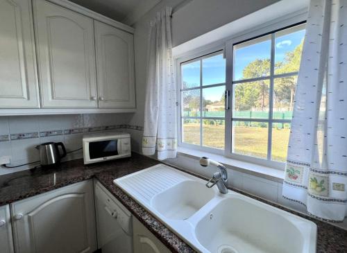 uma cozinha com um lavatório e uma janela em Vila Caravela - Private Pool by HD Properties em Vilamoura