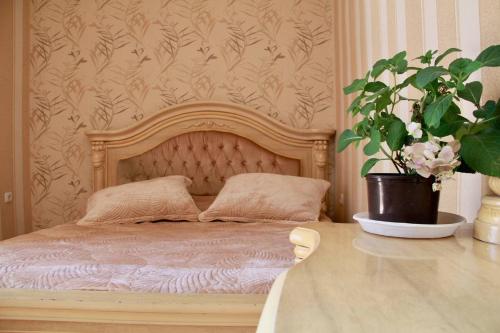 a bedroom with a wooden bed with a potted plant at Rent House in Yerevan