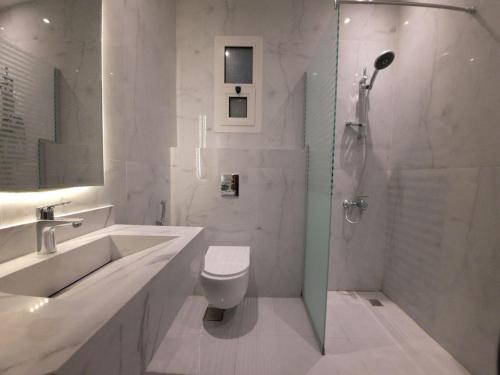 ein Bad mit einer Dusche, einem WC und einem Waschbecken in der Unterkunft دورميرا البوليفارد in Riad