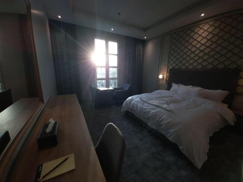 a bedroom with a bed and a table and a window at شقق دورميرا للشقق الفندقية in Riyadh