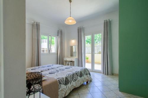 1 dormitorio con 1 cama en una habitación con ventanas en Elsa House ground floor, en Ágios Stéfanos