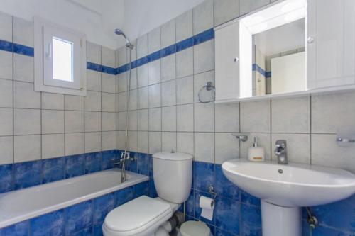 a blue and white bathroom with a toilet and a sink at Elsa House ground floor in Ágios Stéfanos