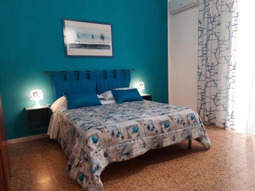 Mary's Sweet Home Napoli في نابولي: غرفة نوم بسرير مع جدار ازرق