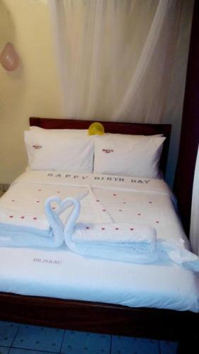 a bed with two heart shaped towels on it at Melvic Hotel in Kisumu
