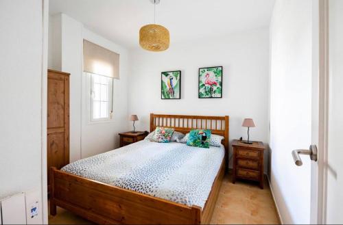 タリファにあるApartamento La Tortuga II Beachのベッドルーム1室(木製ベッド1台、ナイトスタンド2台付)