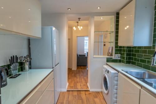 a kitchen with a washer and a sink and a dishwasher at Cheerful and modern 3 BDR for 7 in Liverpool